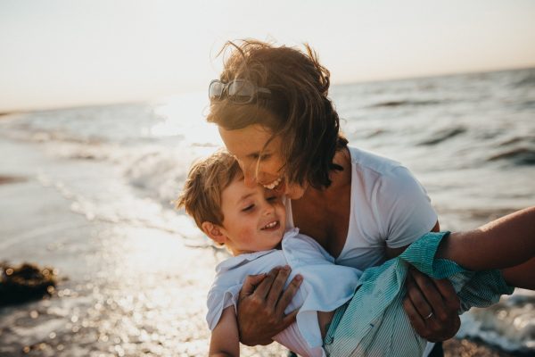 Padre jugando con su hijo en la playa, disciplina positiva en familia